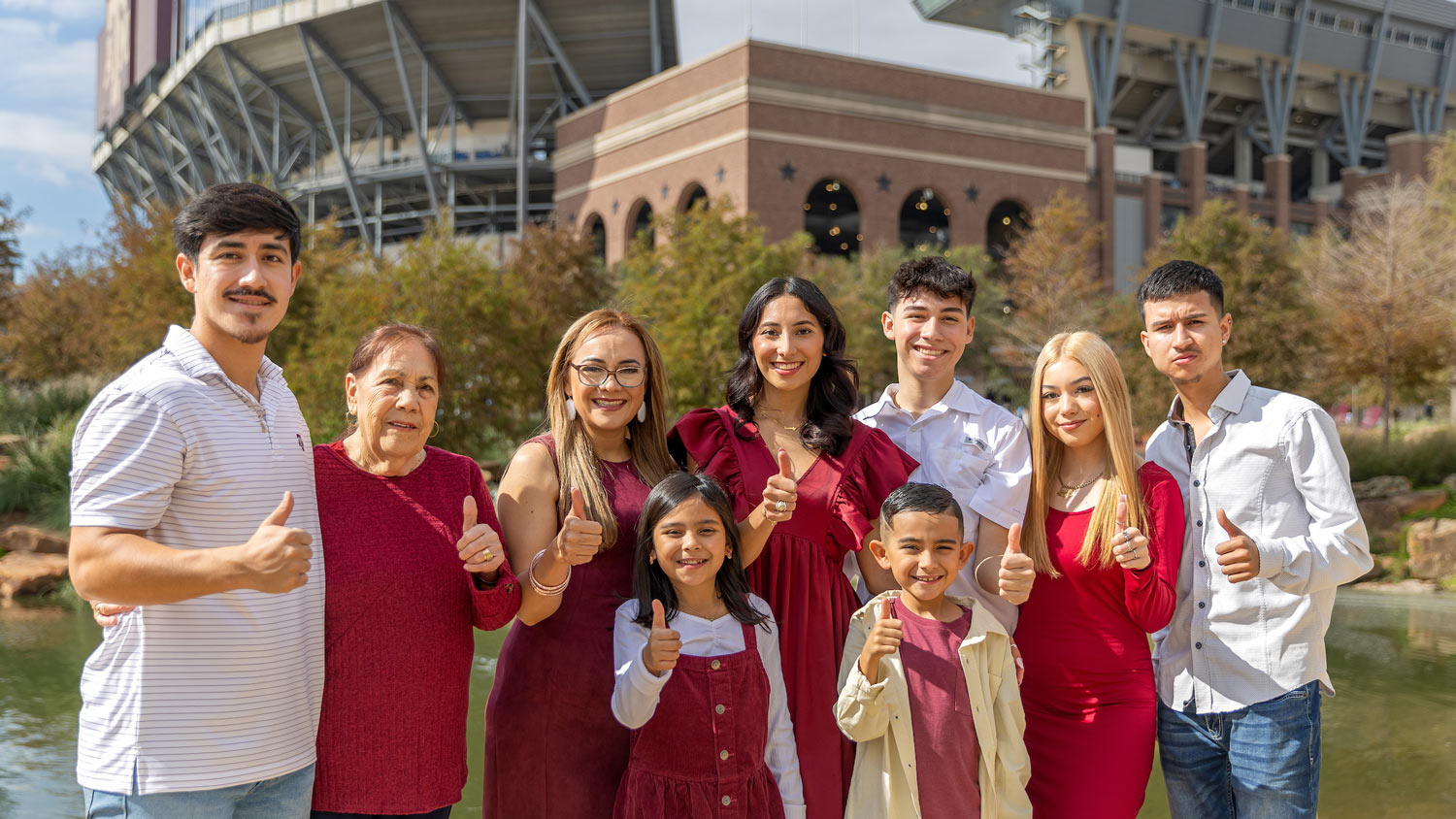 An 91Ƶ on their Ring Day poses with their family in front of Kyle Field