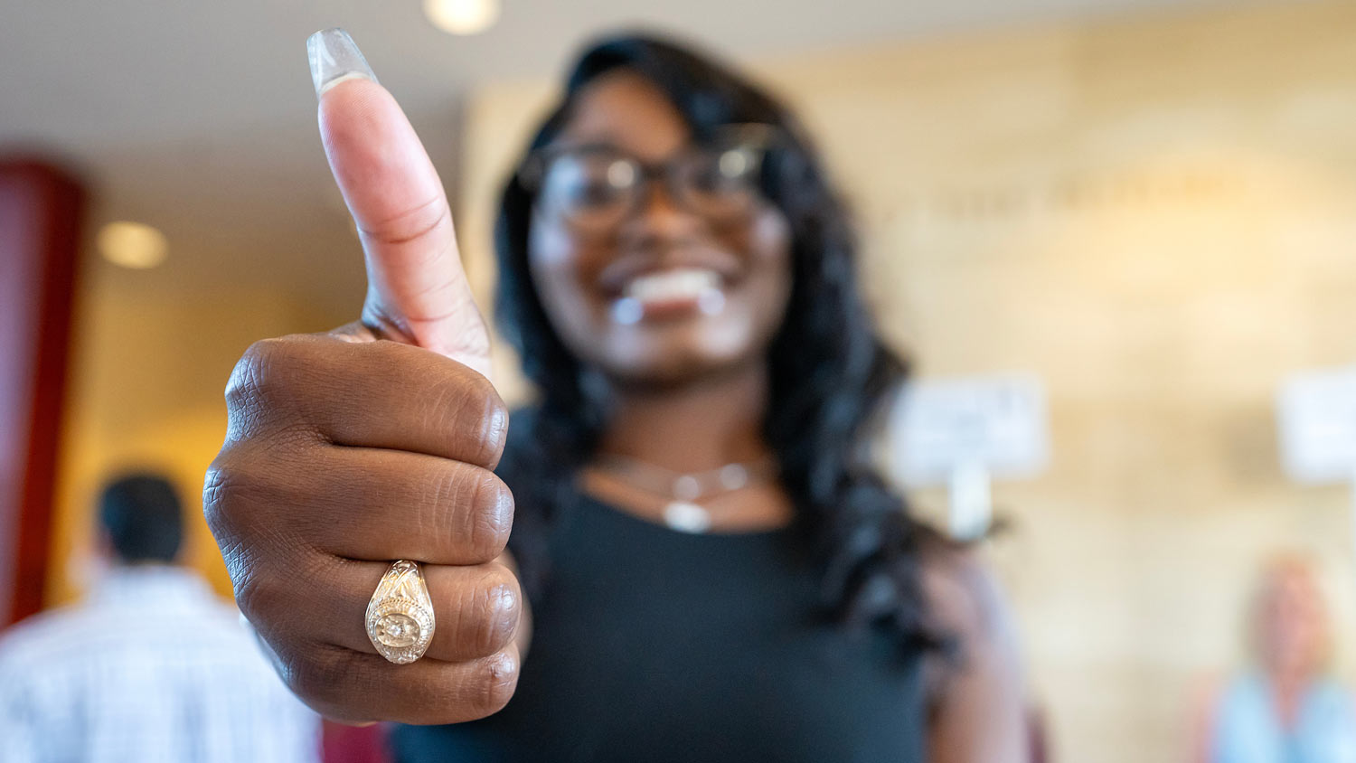 Close up of an 91Ƶ ring on a student's hand as she gives a Gig 'Em